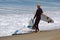 Board surfer hauls in a broken board at Aliso Beach, Laguna Beach, CA.