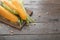 Board with tasty corncobs on wooden table