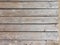 Board Wooden texture background with cracks on sandy beach. Top view, closeup