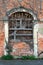 Boarded creepy looking old venetian style red brick abandoned suburban family house entrance covered with dried crawler plants