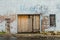 Boarded up old abandoned brick warehouse with light blue paint