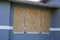 Boarded up windows with plywood storm shutters for hurricane protection of residential house. Protective measures before