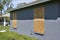 Boarded up windows with plywood storm shutters for hurricane protection of residential house. Protective measures before