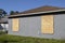 Boarded up windows with plywood storm shutters for hurricane protection of residential house. Protective measures before