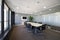Boardroom with long wooden table with black swivel chairs and wall of windows, a large plant, glass partition, carpeted floors and