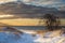 Boardwalk to the beach through dunes covered by fresh snow in winter morning