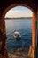 Boat in the Adriatic sea as seen from arched wall in Rovinj at sunset, Istrian Peninsula, Croatia