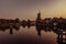 Boat anchored on a canal in Amsterdam at sunrise, windmill