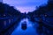 A boat approaching a bridge in Amsterdam at sunset