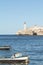 Boat in the Atlantic ocean. View to lighthouse from the seafront. Havana, Cuba. Vertical orientation