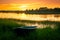 Boat on bank of river at sunset in grass