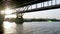 Boat and a barge sail under a bridge over the summer Dnieper in Kyiv, Ukraine.