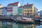 boat and beautiful colorful buildings reflected in calm water of harbor, copenhagen, denmark