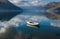 Boat in calm clear full of sky water with mountains background