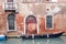 Boat on canal and old brick house in Venice, Italy
