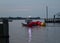 Boat carrying large buoys out to the bay