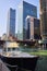 Boat close up with Chicago canal and bridge with skyscraper hotel and offices background, Illinois