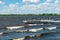 Boat dock with benches on a lake with waves rolling in and city buildings