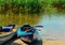 Boat on the dock, blue kayaks on the beach