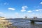 A boat dock in the rough water of lake De Rottemeren with the windmill De Korenmolen in the background on a sunny but stormy day