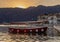 Boat docked in the postcard perfect town of Perast in Kotor Bay with sun setting behind the mountains, Montenegro