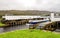 A boat entering the Caledonian Canal from Loch Oich through opened swing bridge near Aberchalder, Scotland