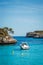 Boat floating on blue sea in Cala Mondrago bay at Mallorca, Spain