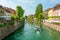 Boat floating down the river passing colorful building.