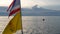 Boat floating near Thai flags in evening. Silhouette of anonymous person floating on boat on rippling sea near Thai and