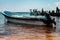 Boat floating on the water with people on the dock in the background in Puerto Morelos, Mexico