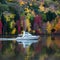 Boat glides through a tapestry of fall colors on the lake