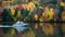 Boat glides through a tapestry of fall colors on the lake