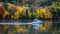 Boat glides through a tapestry of fall colors on the lake