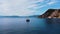 Boat harbour with boat on crystal water at the bottom of rocks.