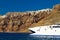 Boat at high volcanic cliff of Santorini island