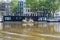 Boat and houseboat in canal. Amsterdam Netherlands. Traditional houses brick faÃ§ade, parked bikes