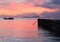 Boat and jetty on sunset sea