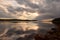 A boat on a lake with a cloudy sky