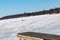 Boat launch ramp at frozen lake with traffic marks on frozen lake surface