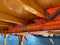 Boat lifesaving equipment life jackets,lots of bright orange color. It is hung under the roof of a passenger ship, intended for