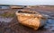 Boat at low tide, moored at the quay at Morston near Holt on the North Norfolk coast, East Anglia UK. Photographed at sundown.