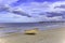 Boat lying on the sand beach at the coast of the island usedom, Germany, under a blue and cloudy sky