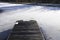 Boat mooring marina in winter snow and ice frozen water and wooden pier jetty at barge sailing club