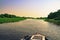 Boat navigating through flooded waters of Pantanal at sunset