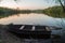 Boat with oars on the river shore at sunset.