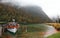 Boat parking on Lake Konigssee with wooden pier and fallen leaves by lakeside on a misty foggy morning
