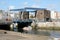 Boat passing under road lifting bridge