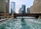 Boat path through ice chunks in a freezing Chicago River which is aqua blue and runs through Chicago Loop as el train speeds by.