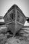 A boat pulled up on a lake shore beach from a dramatic angle in high contrast black and white