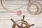 Boat rudder, rope and sea shell on wooden background